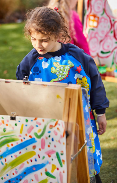 Girl wearing long sleeve Dinosaur art smock