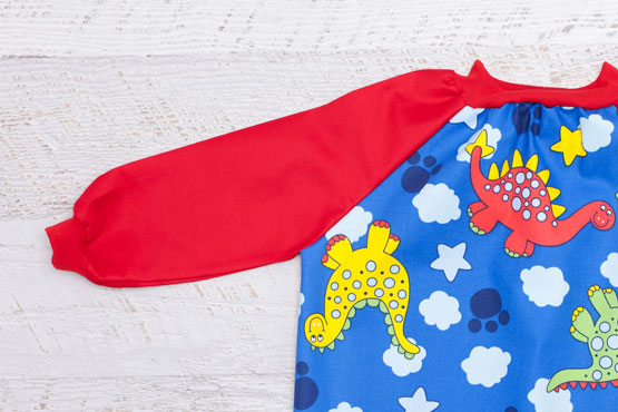 close up of red sleeve on Dinosaur art smock