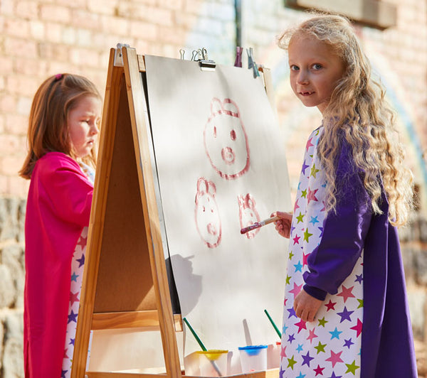 Girl wearing Pink Stars Purple art Smock painting at easel